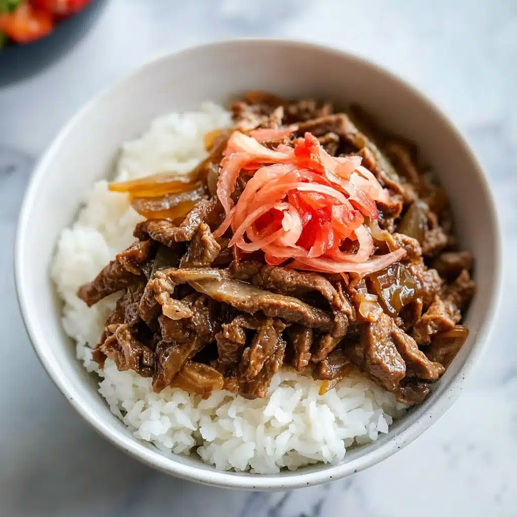 Gyudon Japanese Beef Bowls, Japanese beef bowl recipe, easy Gyudon recipe, authentic Japanese beef bowl, quick Japanese beef dish A white bowl sits on a white marbled surface filled with steamed white rice as the bottom layer, topped with thin, brown cooked beef strips mixed with translucent cooked onion slices. On top, there is a small pile of bright red pickled ginger adding a pop of color. The textures show soft rice, tender beef, and crunchy ginger. A woman's hand is reaching toward the bowl from the right side of the image.