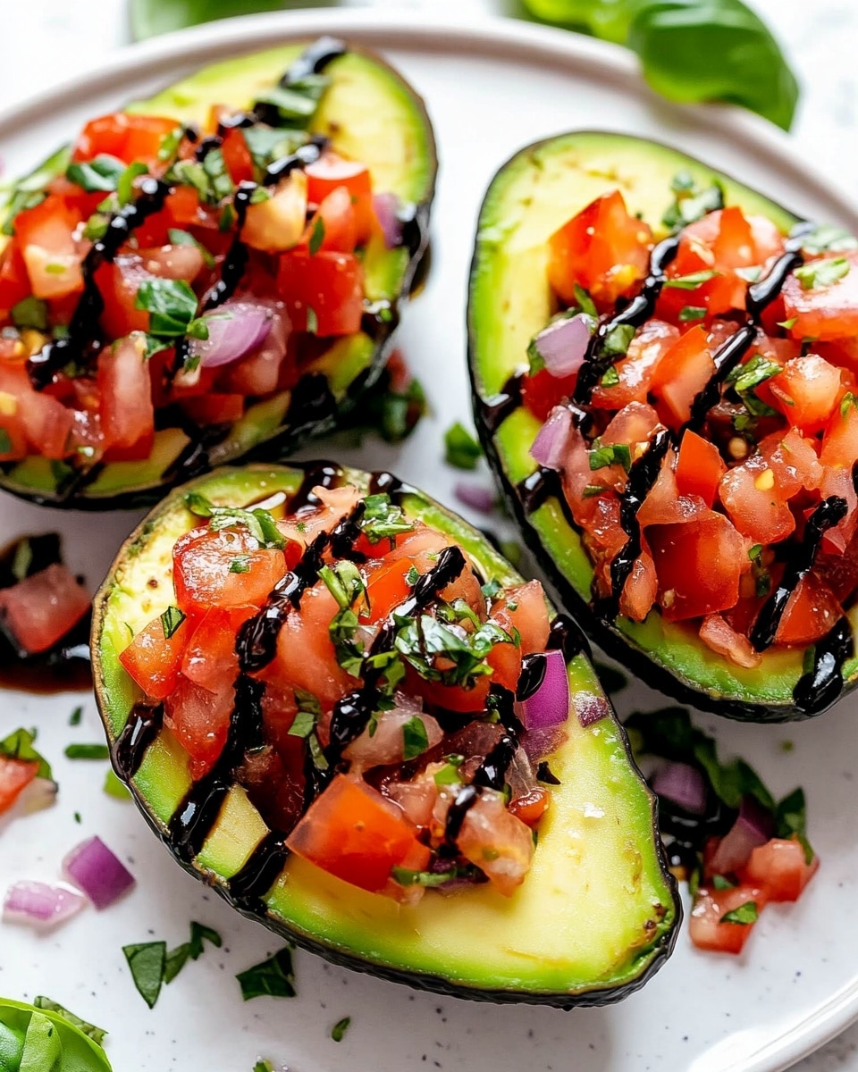 The image shows three avocado halves placed on a white plate with a white marbled surface underneath. Each avocado is filled with a layer of finely chopped red tomatoes and purple onions mixed with green herbs. The smooth light green avocado flesh surrounds the colorful topping. A dark glossy balsamic glaze is drizzled over the top of the tomato mixture, adding a shiny contrast. Around the plate, there are a few small basil leaves and some extra tomato pieces for decoration. The overall colors include the creamy green of avocado, bright red and purple of the tomato and onion mix, dark green of herbs, and shiny black from the glaze. Photo taken with an iphone --ar 4:5 --v 6.1