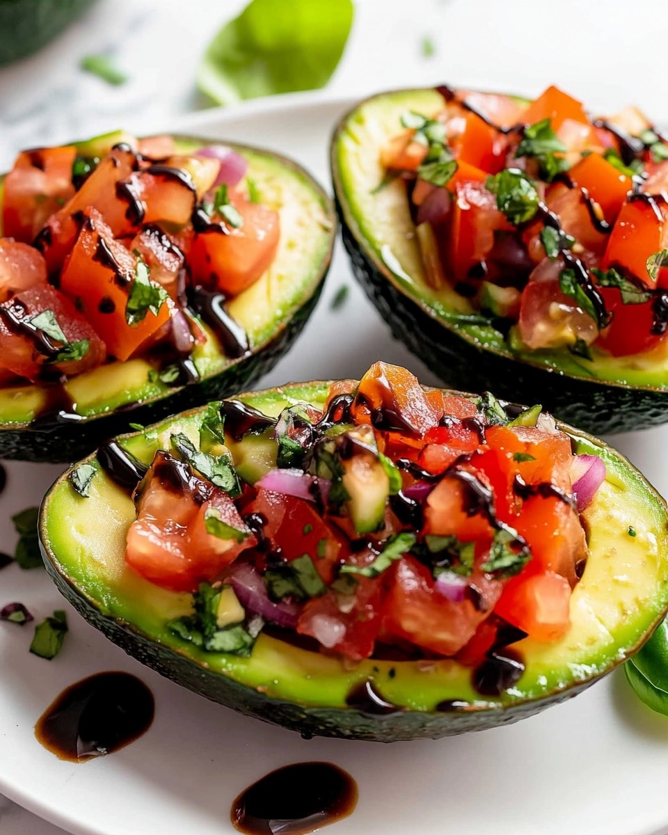 The image shows halved avocados with the skin on, filled with three main layers. The bottom layer is the light green creamy avocado flesh with light grill marks including dark grill lines. On top of this is a chunky bright red tomato mixture with visible small pieces of purple onion and green herbs. The top layer has thin white shavings of cheese scattered unevenly over the tomato mix. The stuffed avocados rest on fresh, deep green basil leaves arranged on a white plate. Drops of dark balsamic glaze are drizzled over the avocado and plate, adding contrast. The background shows a white marbled texture. photo taken with an iphone --ar 4:5 --v 6.1