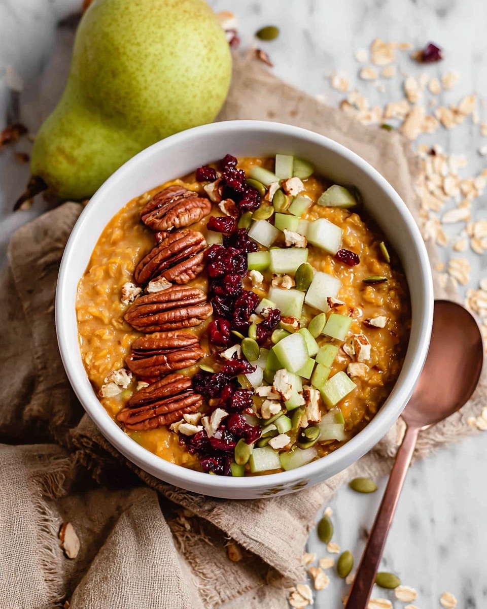 A white bowl filled with a thick orange oatmeal base topped with three main layers: large pecans placed in a neat line on the left, small green and white diced pear pieces in the middle, and scattered red dried cranberries, green pumpkin seeds, and oat flakes over the top and right side. The bowl sits on a beige cloth with loose oats and seeds around, resting on a white marbled surface. A whole green pear is placed behind the bowl, and a copper spoon with some seeds is positioned in the lower left corner. Photo taken with an iphone --ar 4:5 --v 7
