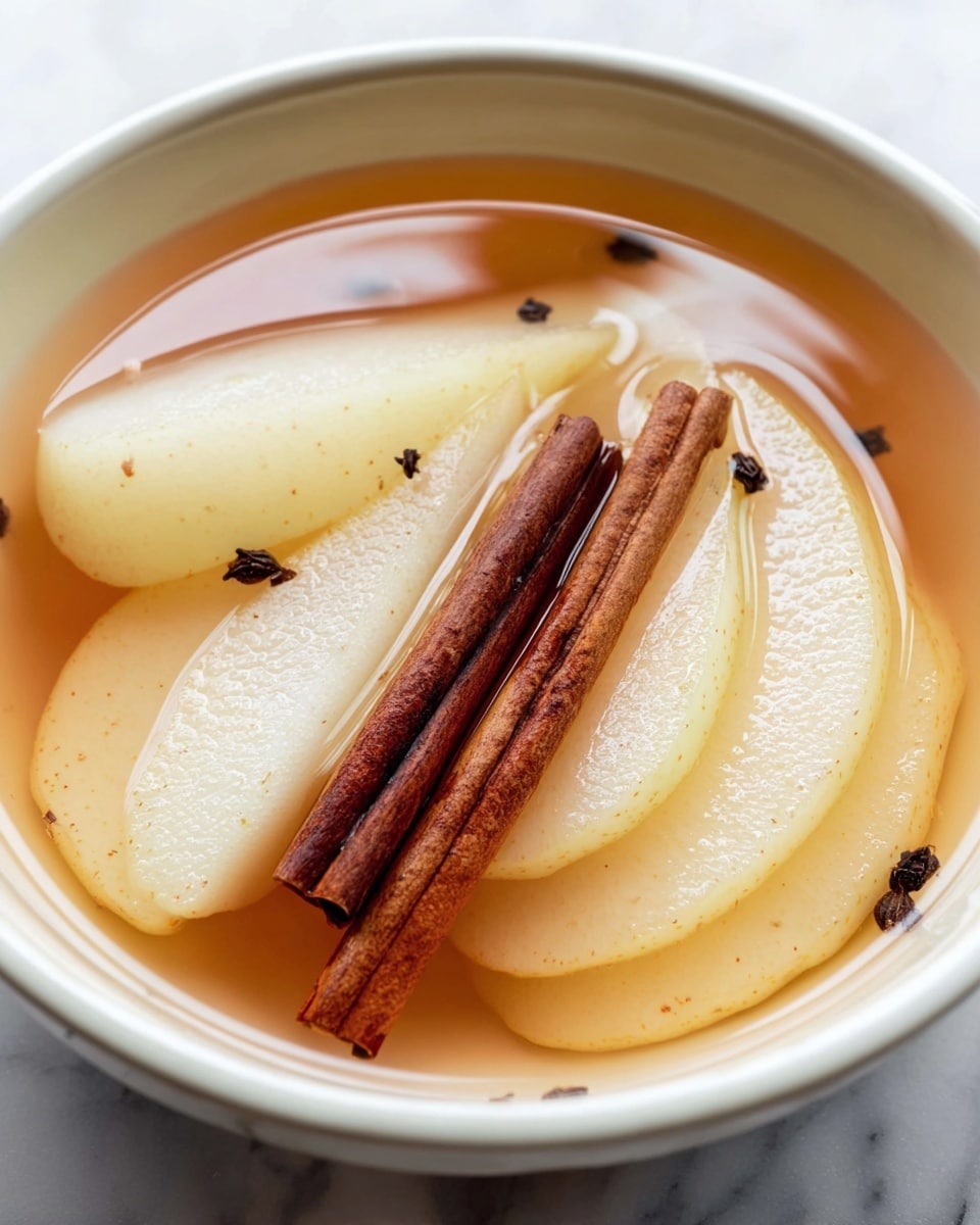 The image shows a white bowl with a light blue rim filled with sliced pears soaked in amber-colored syrup. There are seven pale yellow pear slices arranged in the liquid, showing a soft and smooth texture. On top of the pears, three brown cinnamon sticks lie parallel to each other. The bowl is placed on a white marbled surface, with two whole greenish-brown pears, a small white bowl of light brown sugar, a vanilla bean, and a halved lemon in the blurry background. The overall look feels fresh and inviting, with warm tones from the syrup and cinnamon photo taken with an iphone --ar 4:5 --v 7