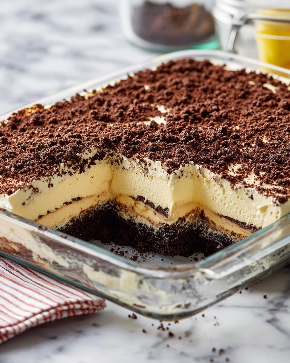 A square slice of layered dessert is on a white plate placed on a white marbled surface. The bottom layer is dark brown, moist, and crumbly like a chocolate base. The middle layer is thick, smooth, and creamy in a light cream color, slightly spilling out on the sides. The top layer is made up of fine, dark brown crumbs covering the creamy layer fully. A silver fork with a piece of the dessert speared on it is beside the slice, showing the layers clearly. Photo taken with an iphone --ar 4:5 --v 7