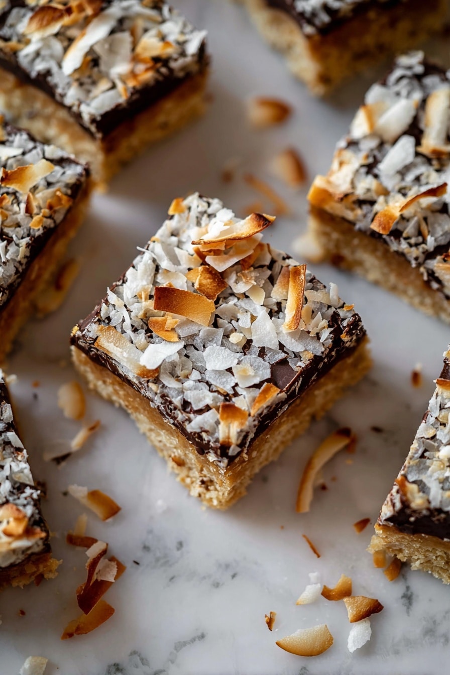 The image shows several square dessert bars arranged closely together on a white marbled surface. Each bar has three visible layers: the bottom layer is a dense, crumbly brown base, the middle layer is a rich, dark chocolate, and the top layer is covered with toasted coconut flakes that are light brown and white, adding a flaky texture. Some toasted coconut flakes are scattered around the bars on the surface. Photo taken with an iphone --ar 2:3 --v 7 - Pumpkin Gooey Bars with Chocolate Chips and Coconut, fall dessert recipes, pumpkin dessert ideas, chocolate chip pumpkin bars, easy autumn treats