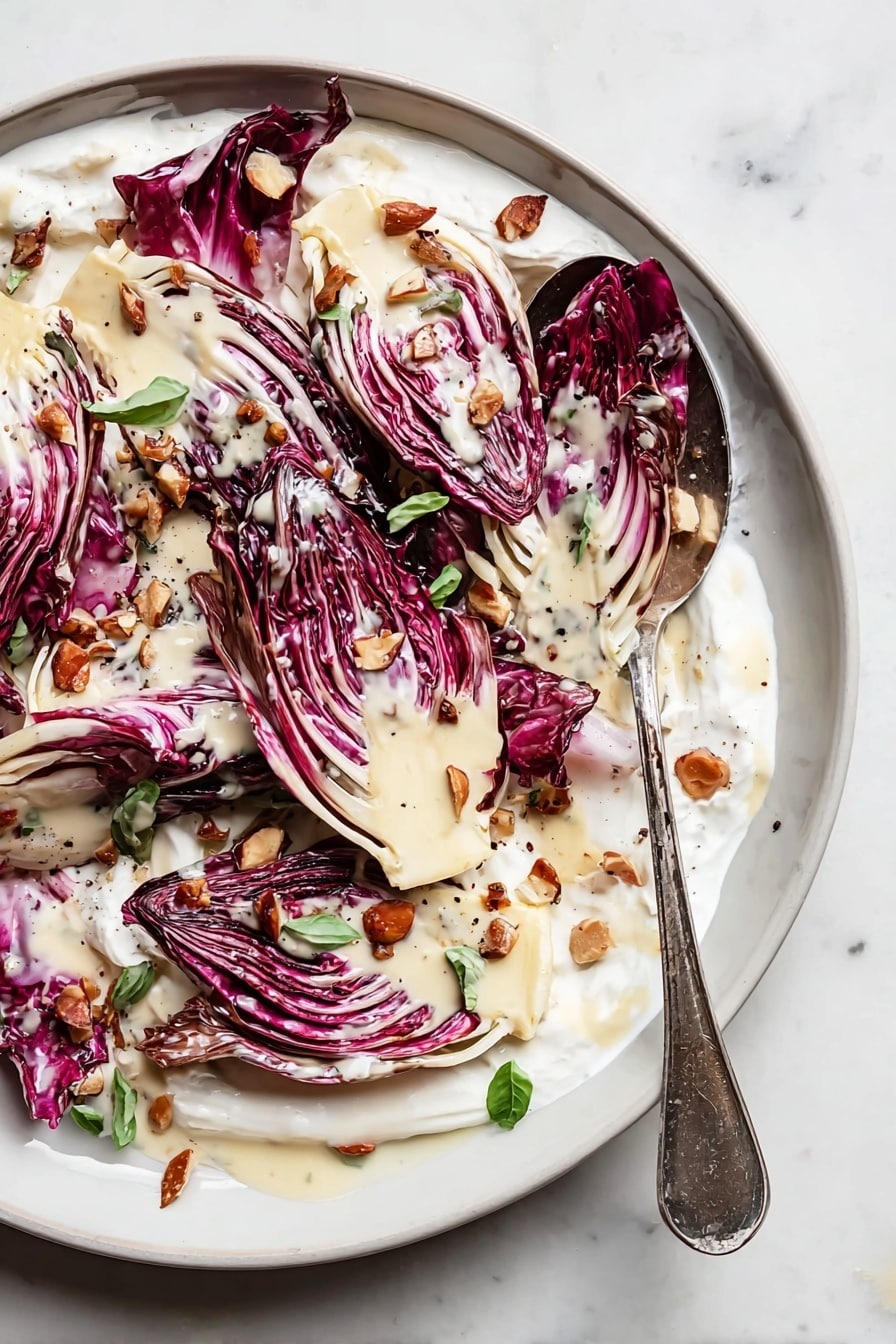 The image shows a white plate with several layers of grilled radicchio leaves that are reddish-purple with white veins, arranged overlapping in a circular pattern. The leaves are lightly charred on the edges giving a slightly darkened texture. A light cream-colored sauce is drizzled unevenly over the radicchio, pooling slightly on the plate. Scattered on top are small pieces of chopped toasted hazelnuts with a golden-brown color, adding texture and contrast. Small green herb leaves are also sprinkled sparingly across the dish for a fresh touch. The plate rests on a white marbled surface. photo taken with an iphone --ar 2:3 --v 7 - Radicchio Salad with Crème Fraîche Vinaigrette, grilled radicchio salad, bitter greens salad, creamy vinaigrette salad, healthy radicchio recipes