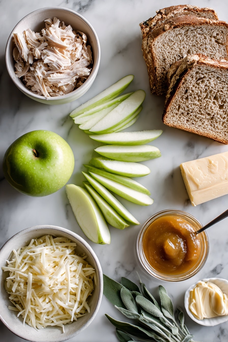 Flat lay of crisp green Granny Smith apple slices, thinly chopped fresh sage leaves, a neat pile of shredded white sharp cheddar cheese, tender folded slices of deli turkey, thick rustic whole wheat sourdough bread slices, smooth glossy apple butter spread in a small dollop, and a small pat of light butter spread, all beautifully arranged on a white marble surface, photo taken with an iphone --ar 2:3 --v 7 - Apple Grilled Cheese with Turkey, savory turkey grilled cheese, apple and cheese sandwich, quick lunch recipes, easy gourmet sandwiches