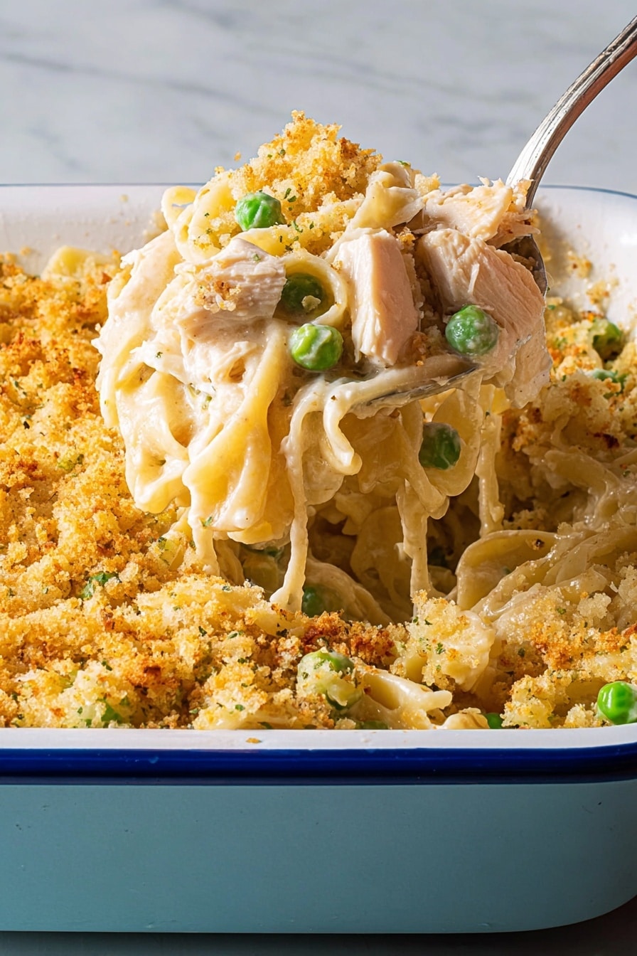 A close-up of a fork full of creamy spaghetti pasta mixed with small green peas, sliced brown mushrooms, and light-colored pieces of chicken. The spaghetti strands are coated in a smooth, light yellow cheese sauce that looks thick and creamy. The background shows a blurred white marbled texture. Photo taken with an iphone --ar 2:3 --v 7 - Thanksgiving Turkey Tetrazzini, Turkey Tetrazzini with leftovers, creamy turkey pasta casserole, holiday turkey leftovers recipe, cozy comfort food recipes