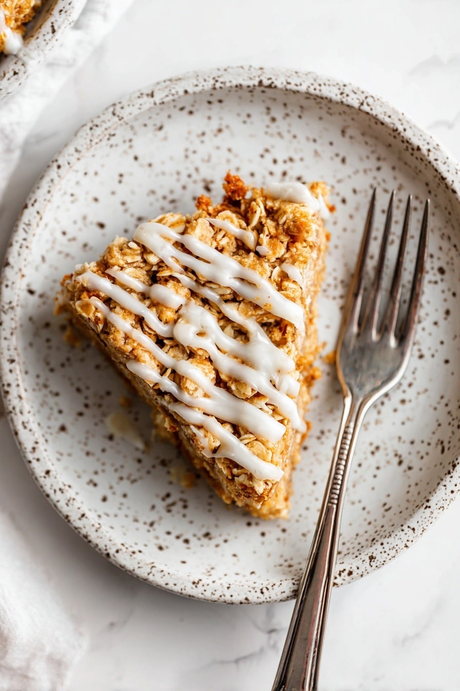 The image shows a round oat crumble bar cut into slices on a white marbled surface. It has one thick layer made up of golden brown baked oats mixed with small nut pieces, giving it a rough and crunchy texture. The top is drizzled with a light creamy glaze spread unevenly over the oats, adding a glossy, smooth contrast. One slice is slightly pulled out, showing the bar’s thickness and dense oat texture inside. There is some scattered cinnamon powder to the right on the surface, adding a warm touch. The overall colors are warm golden and beige with white glaze highlights. photo taken with an iphone --ar 2:3 --v 7 - Apple Coffee Cake, easy apple coffee cake, moist apple coffee cake, homemade apple coffee cake, apple coffee cake with streusel