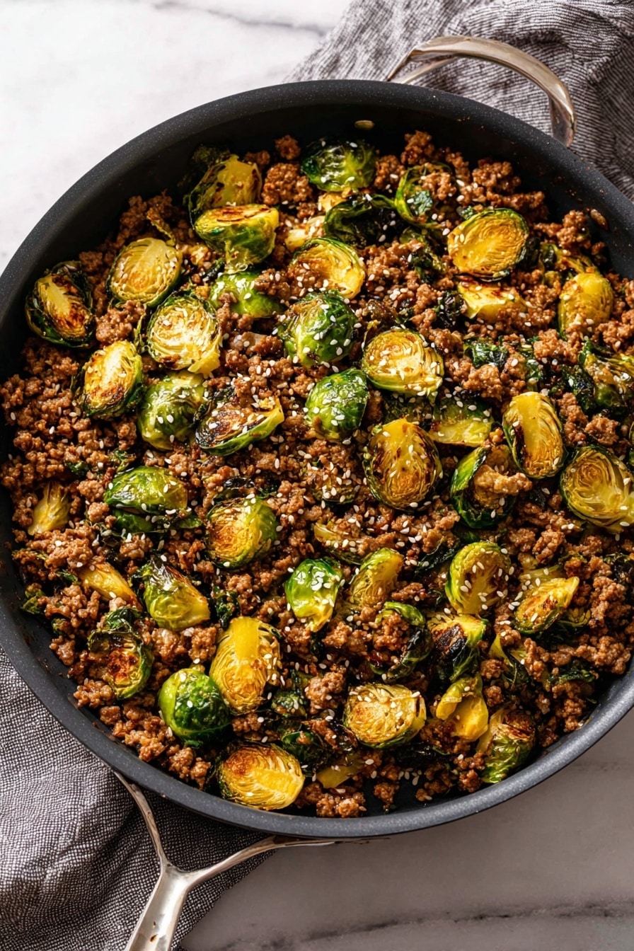 This dish shows a close-up of a cooked mix with two main layers: crumbled brown cooked ground meat and halved roasted Brussels sprouts with crispy green leaves, all cooked together. The meat is dark brown and looks juicy, covering most of the image with small chunks and a rough texture. The Brussels sprouts are bright yellow-green with some parts browned and caramelized on the edges. White sesame seeds are sprinkled over the whole dish, adding a little contrast. In the center, a wooden spoon scoops up a portion, lifting some of the mix, showing the layers well. The dish is set on a white marbled surface. Photo taken with an iphone --ar 2:3 --v 7 - Ground Beef and Brussels Sprouts Stir-Fry with Sweet Chili and Lime, healthy ground beef stir-fry, quick weeknight dinner recipe, easy stir-fry with Brussels sprouts, flavor-packed beef stir-fry