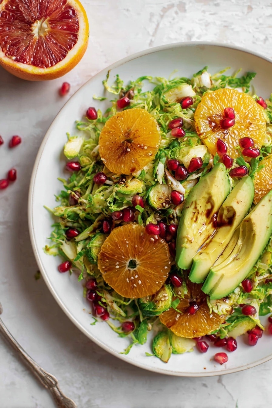 The image shows a close-up of a fresh salad featuring a large slice of avocado with smooth green skin and creamy light green flesh in the center. The avocado is topped with dark brown dressing, pooling in its seed cavity with a pomegranate seed sitting in the middle of the dressing. Surrounding the avocado are layers of bright red pomegranate seeds and shredded pale green lettuce. In the background, there are segments of orange with a juicy texture, adding a pop of vibrant orange color. The salad is placed on a white marbled surface, enhancing the freshness and colors of the ingredients. Photo taken with an iphone --ar 2:3 --v 7 - Citrus Brussels Pomegranate Salad, healthy citrus salad, easy Brussels sprouts salad, festive fruit and vegetable salad, quick side salad recipes