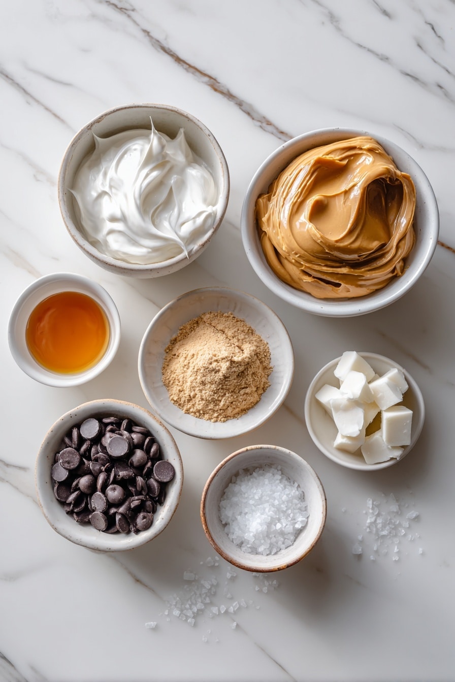 Flat lay of a small mound of creamy white full-fat Greek yogurt in a simple white ceramic bowl, a neat heap of light tan powdered peanut butter on a white plate, a dollop of smooth creamy peanut butter on a white ceramic dish, a small white bowl of golden maple syrup, a small white bowl filled with glossy dark chocolate chips, a small white bowl holding solid white coconut oil chunks, and a few delicate flakes of flaky sea salt scattered artfully beside the bowls, all arranged symmetrically and balanced, placed on a clean white marble surface, soft natural light, photo taken with an iPhone, professional food photography style, fresh ingredients, white ceramic bowls, no bottles, no duplicates, no utensils, no packaging --ar 2:3 --v 7 - High Protein Frozen Peanut Butter Greek Yogurt Bites, healthy protein snacks, easy frozen yogurt bites, nutritious peanut butter dessert, no-bake high protein treat
