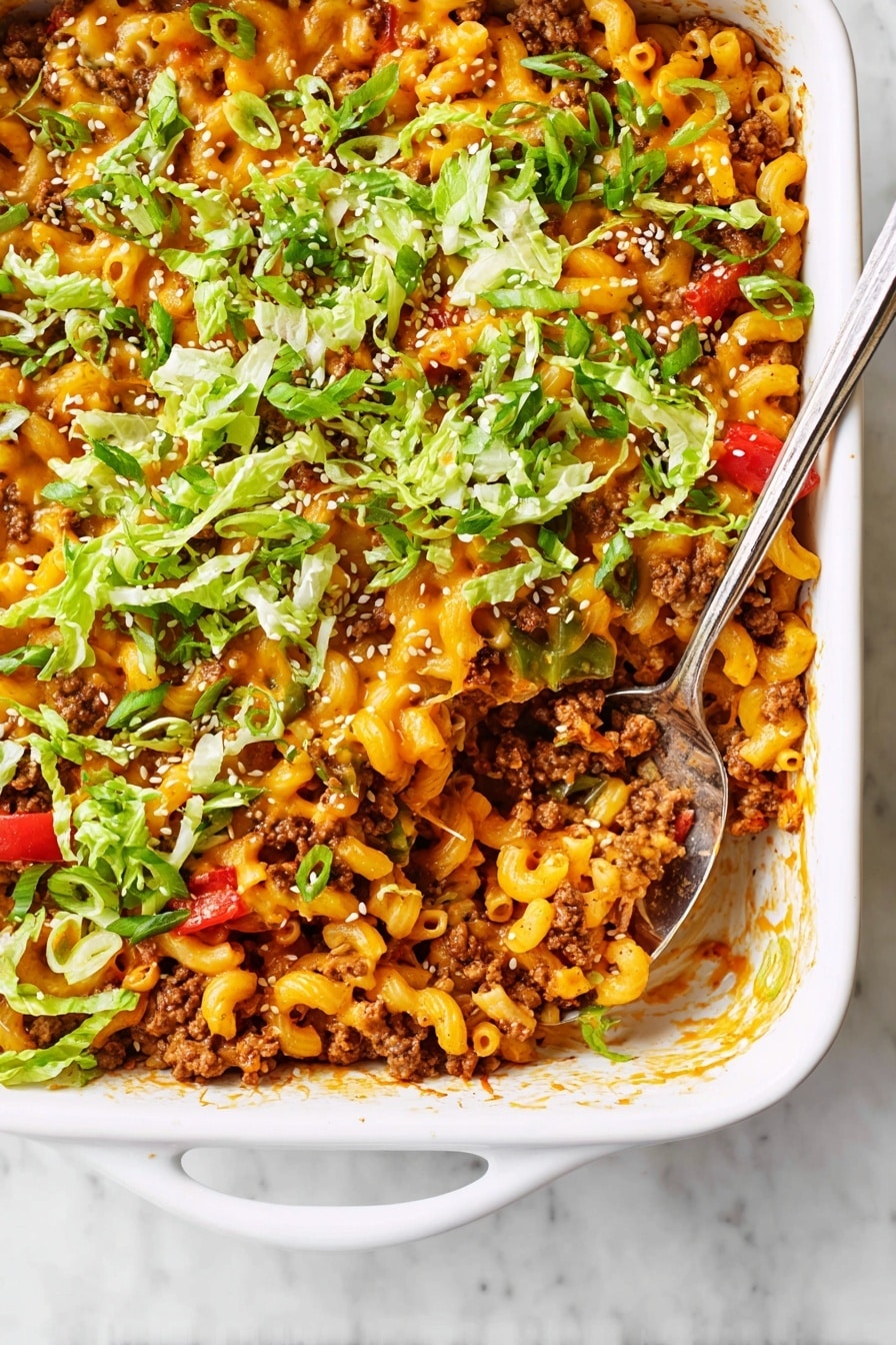 The image shows a white dish filled with a mix of curly pasta, cooked ground meat, and melted orange cheese, all combined in one layer. Scattered throughout are pieces of red tomatoes and fresh green lettuce, adding color and freshness. The dish is topped with small white sesame seeds sprinkled evenly, and a silver spoon scoops a portion, lifting some pasta and toppings. The overall texture is creamy with bits of soft and tender ingredients visible against a white marbled background. Photo taken with an iphone --ar 2:3 --v 7 - Cheddar Hamburger Casserole, cheesy hamburger casserole, easy hamburger casserole recipe, hearty casserole with cheddar, comfort food hamburger bake