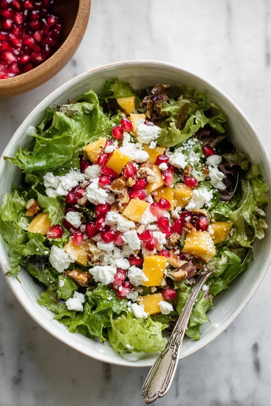 A white bowl filled with a fresh salad showing three main layers: at the bottom, bright green leafy lettuce with a curly texture; on top of the greens, vibrant red pomegranate seeds and small pieces of light brown nuts scattered around; covering everything are crumbles of white cheese adding a soft, creamy texture. A silver spoon rests inside the bowl, partially immersed in the salad. The bowl sits on a light wooden surface with some extra pomegranate seeds and cheese crumbles scattered around for a natural touch. Photo taken with an iphone --ar 2:3 --v 7 - Festive Pomegranate Walnut Salad, holiday salad recipes, easy holiday salads, colorful fruit and nut salads, healthy holiday side dishes