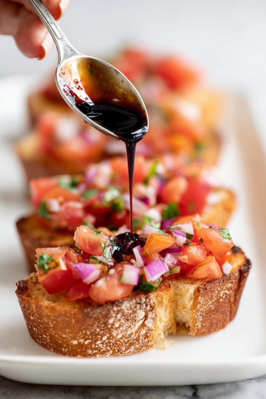 The image shows a white plate on a white marbled surface, filled with several round slices of crusty bread arranged close to each other. Each bread slice is topped with a fresh mix of chopped red tomatoes, small pieces of purple onion, green basil leaves, and tiny bits of white nuts or cheese, giving a colorful and fresh look. The bread has a golden-brown crust with a soft inside, and the toppings are slightly glossy, suggesting a light drizzle of oil or seasoning. The focus is sharp on the front pieces and gradually blurs toward the back, highlighting the texture and freshness of the toppings. photo taken with an iphone --ar 2:3 --v 7 - Tomato Bruschetta with Balsamic Glaze, easy tomato appetizer, fresh bruschetta recipe, homemade tomato tapa, balsamic glazed bruschetta