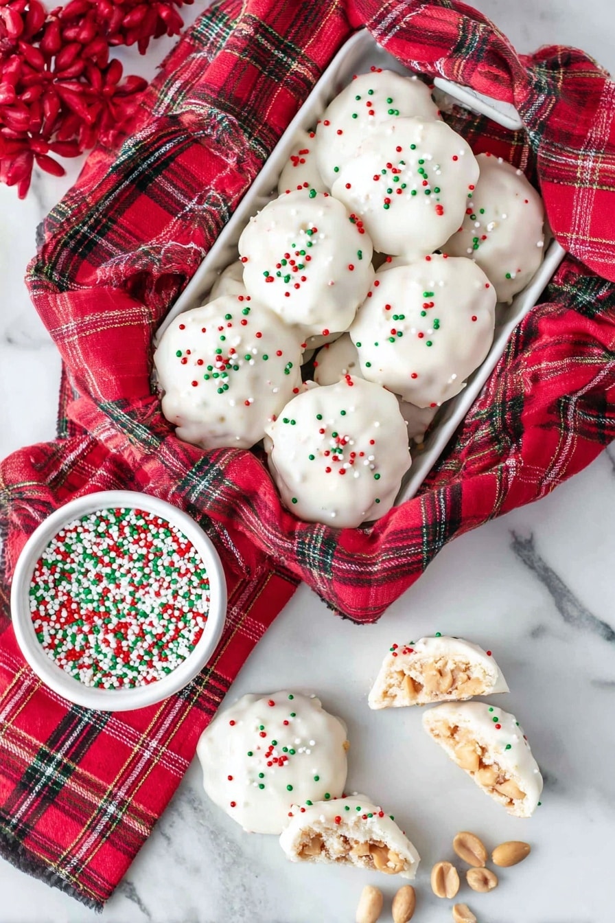 The image shows a white tray lined with a red plaid cloth, holding six white chocolate-covered cluster cookies sprinkled with small red, green, and white round sprinkles. Next to the cookies, there's a white bowl filled with the same red, green, and white sprinkles. Below the tray on the cloth, four more cluster cookies are arranged, with two cut in half showing a crunchy peanut inside under the smooth white chocolate coating. A few peanuts are scattered near the cookies. The setting is on a white marbled surface. Photo taken with an iphone --ar 2:3 --v 7 - Polar Bear Paws Caramel Peanut Clusters, caramel peanut clusters, white chocolate candy, holiday treats, easy candy recipes