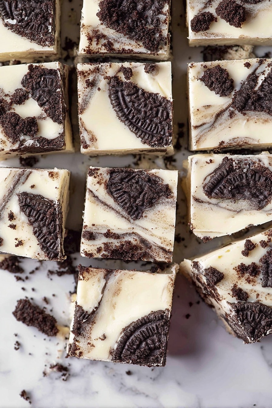 The image shows nine square pieces of a dessert with three visible layers: the bottom layer is a dark brown chocolate base, the middle layer is a creamy white cheesecake layer with a smooth texture, and the top layer is a scattered arrangement of whole and broken Oreo cookie pieces in dark brown with detailed patterns. The squares are arranged close together on a white marbled surface, with some crumbs scattered around. Photo taken with an iphone --ar 2:3 --v 7 - Easy Oreo Fudge, Oreo Fudge, no-bake Oreo dessert, simple fudge recipe, quick Oreo treats