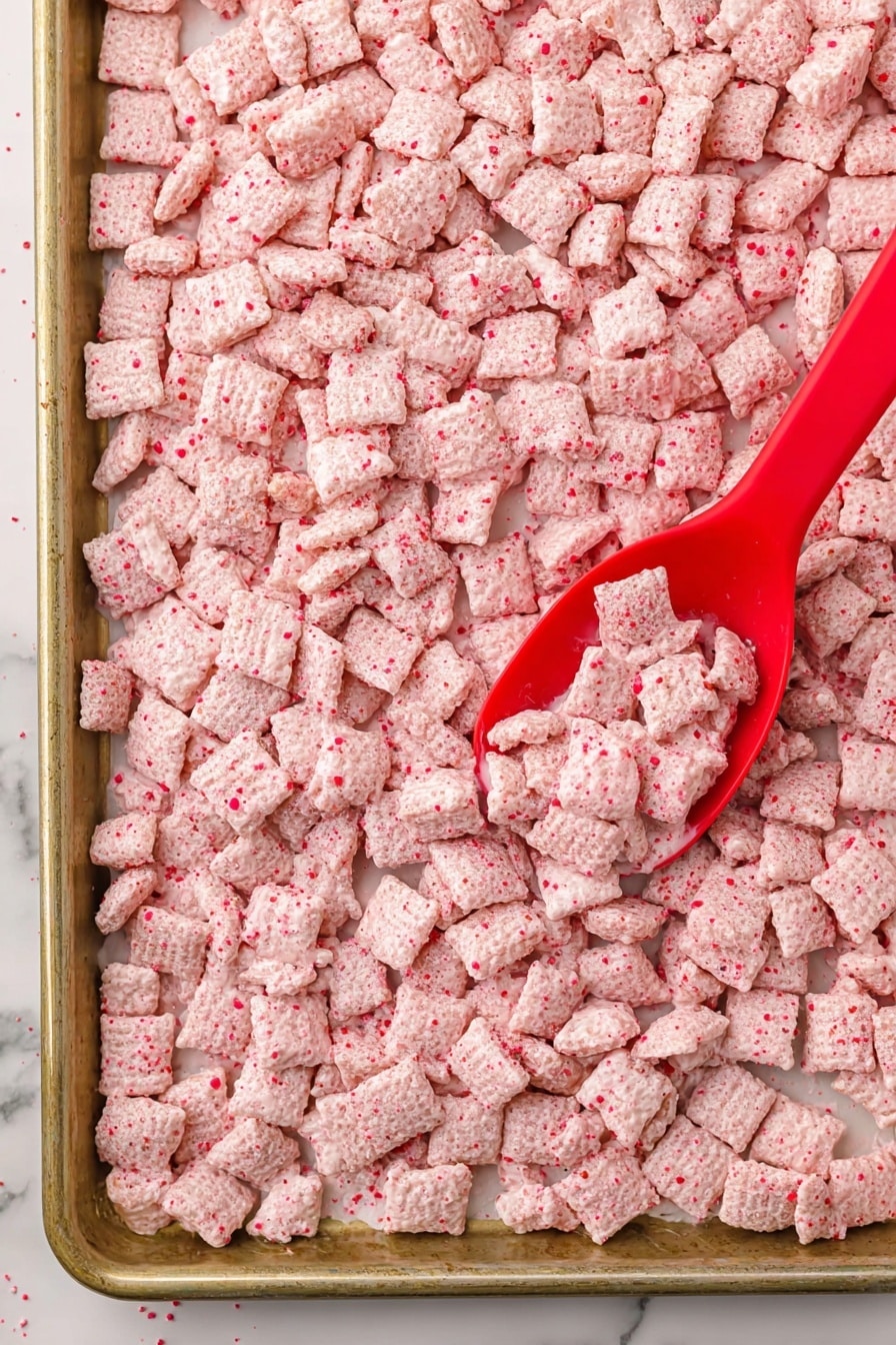 A clear glass jar is shown tilted on its side, spilling out light pink, square cereal pieces that have a rough, crumbly texture with small red flakes throughout. The jar's metal clasp and rubber seal are visible, and a small candy cane is hooked on the jar's open lid. More cereal pieces fill another glass container in the blurry background. The scene sits on a white marbled surface with some Christmas decorations blurred behind, including red and silver balls and candy canes. photo taken with an iphone --ar 2:3 --v 7 - Peppermint Bark Puppy Chow, festive puppy chow, holiday snack recipes, peppermint treats, crunchy cereal snacks
