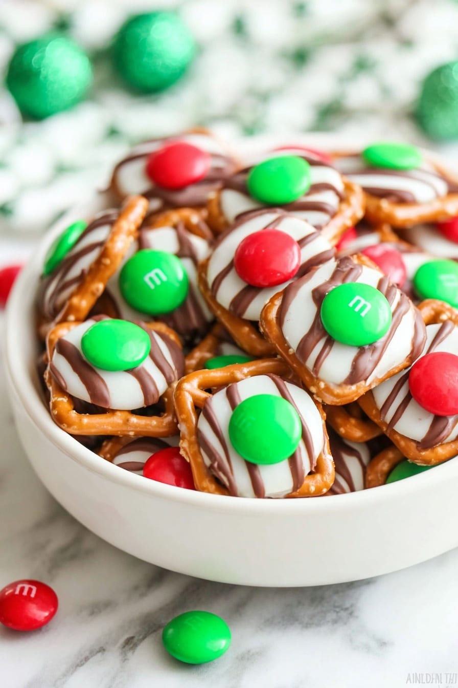 The image shows many small square pretzels as the base layer, each topped with a white and brown striped candy that looks soft and round, placed in the center of each pretzel. On top of this candy, a single green or red shiny round candy is placed firmly. All the pieces are closely arranged, covering the frame, and they sit on a white marbled textured surface. The colors are bright and festive with the contrast of white, brown, red, and green. photo taken with an iphone --ar 2:3 --v 7 - Chocolate Pretzel Hugs with M&Ms, easy holiday treats, no-bake chocolate snacks, salty sweet pretzel bites, festive chocolate M&Ms desserts