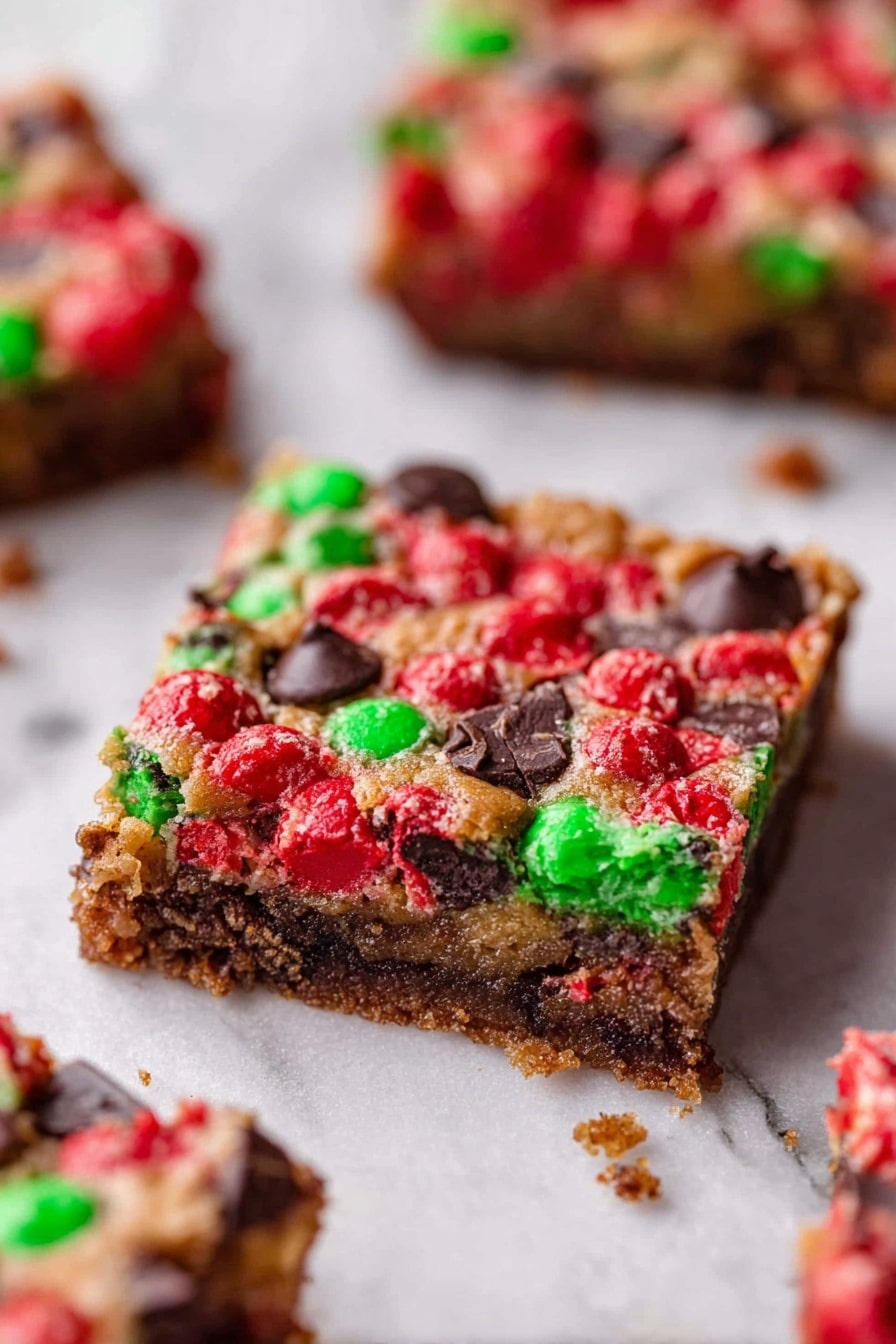 The image shows three square bars stacked on top of each other, each about one inch thick. The bottom layer is a light golden brown cookie-like base with a rough texture, filled with colorful red and green candy pieces and melted dark chocolate chunks. The middle layer is similar but slightly darker from the melted chocolate blending with the cookie base, with more visible candy pieces and chocolate. The top layer is rich and uneven in texture, with generous amounts of melted dark chocolate and candy coating the surface, adding bright red and green spots. The bars sit on a white marbled surface, with scattered red and green candy pieces around them. Photo taken with an iphone --ar 2:3 --v 7 - Christmas Magic Cookie Bars, holiday cookie bars, festive dessert recipes, easy Christmas treats, chocolate coconut M&M's bars