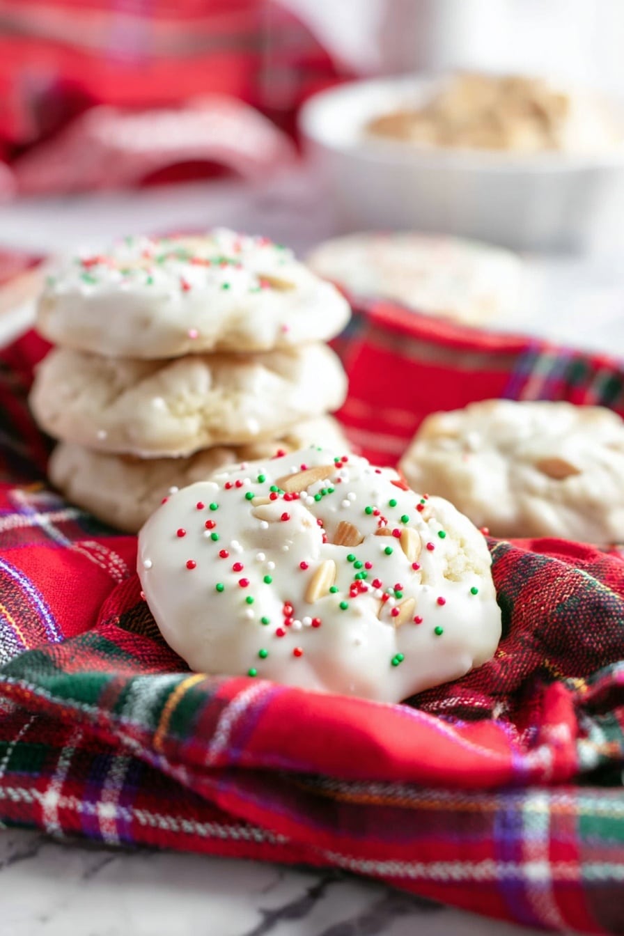 The image shows two thick layers of white candy with red, green, and white round sprinkles on top. Inside each candy layer, there is a middle filling layer that is light brown and contains whole peanuts visible through the soft texture. The candy is placed on a white marbled surface, with a red and green plaid cloth in the background, adding a festive look. The layers are stacked with one candy piece laying flat and two pieces leaning on each other, showing the inside clearly. Photo taken with an iphone --ar 2:3 --v 7 - Polar Bear Paws Caramel Peanut Clusters, caramel peanut clusters, white chocolate candy, holiday treats, easy candy recipes